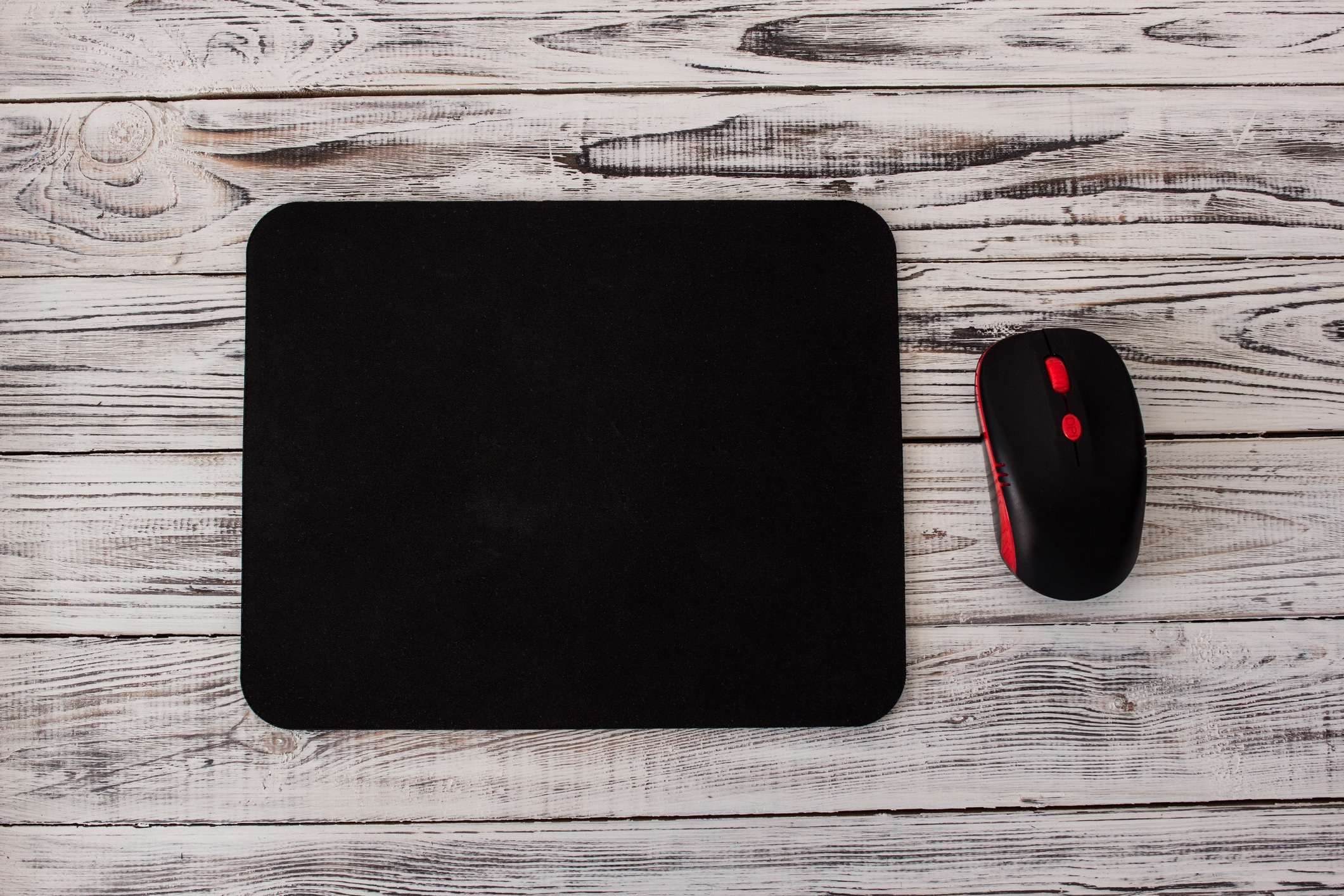 Black computer mousepad with a mouse on a white wooden background mousepad